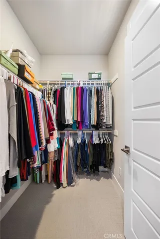 a view of walk in closet with clothes and shoes