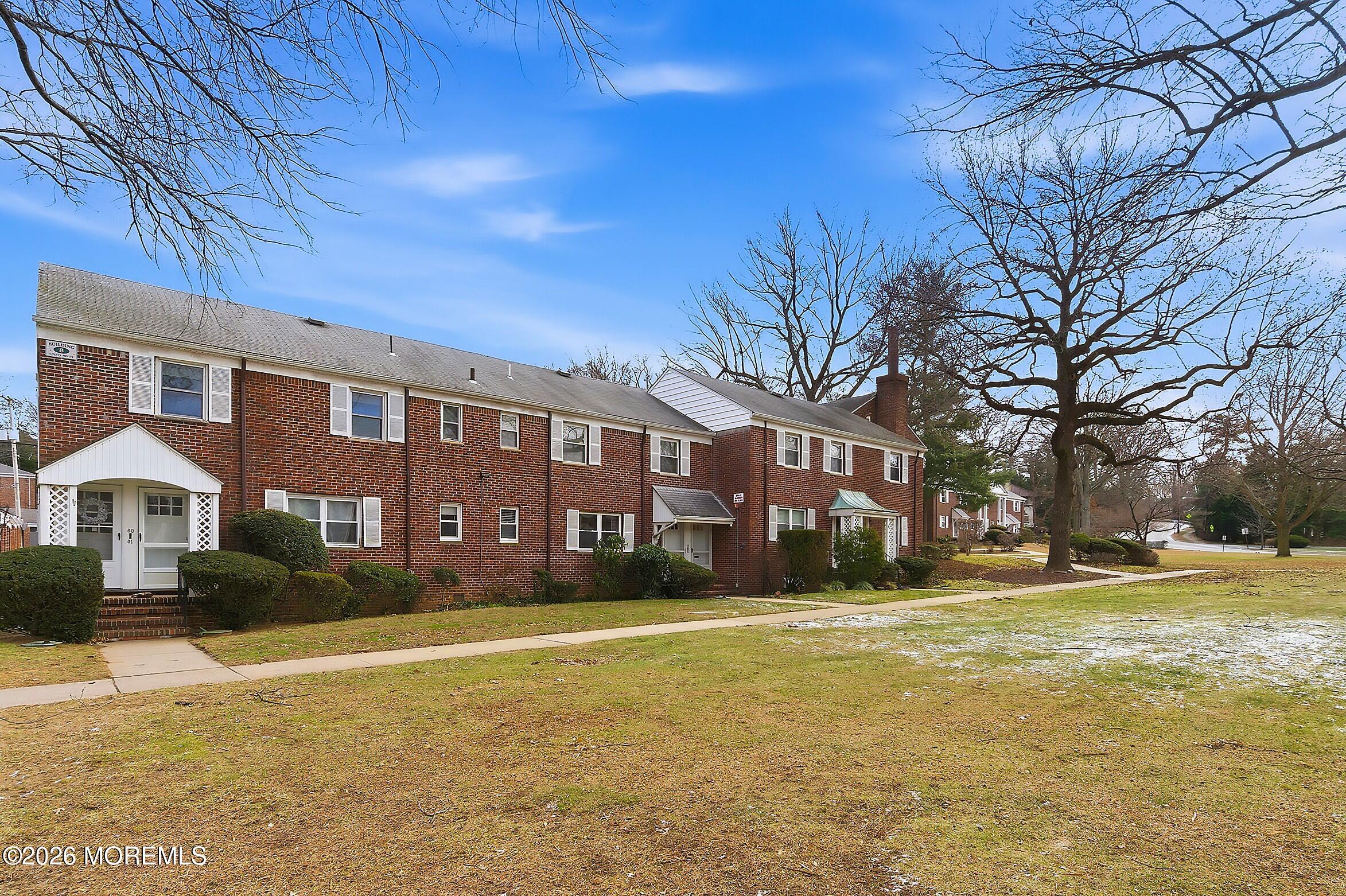 a front view of residential houses with yard and trees