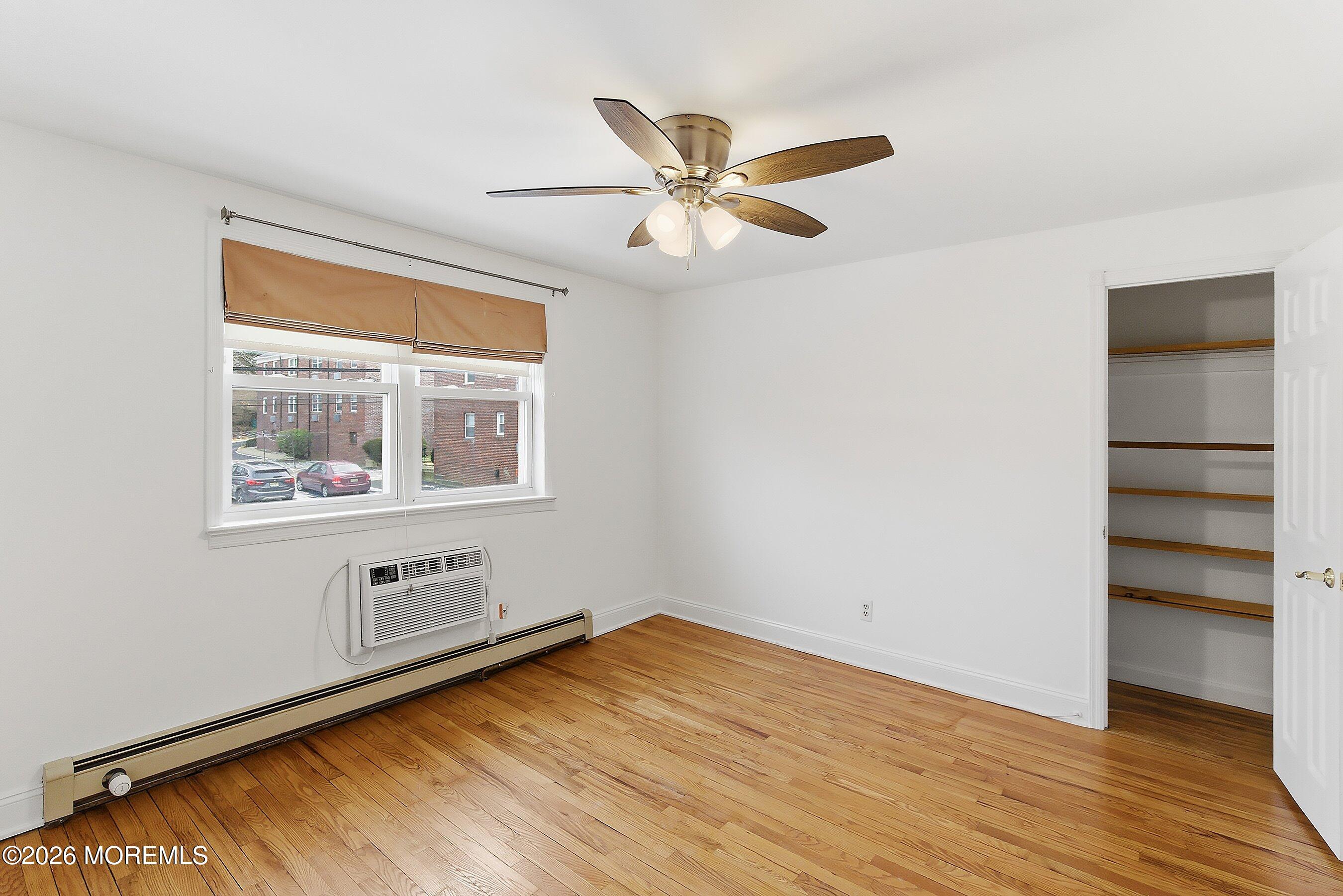 83 Manor Drive Red Bank, NJ 07701 - Photo 12 of 16 a view of an empty room with a window and wooden floor