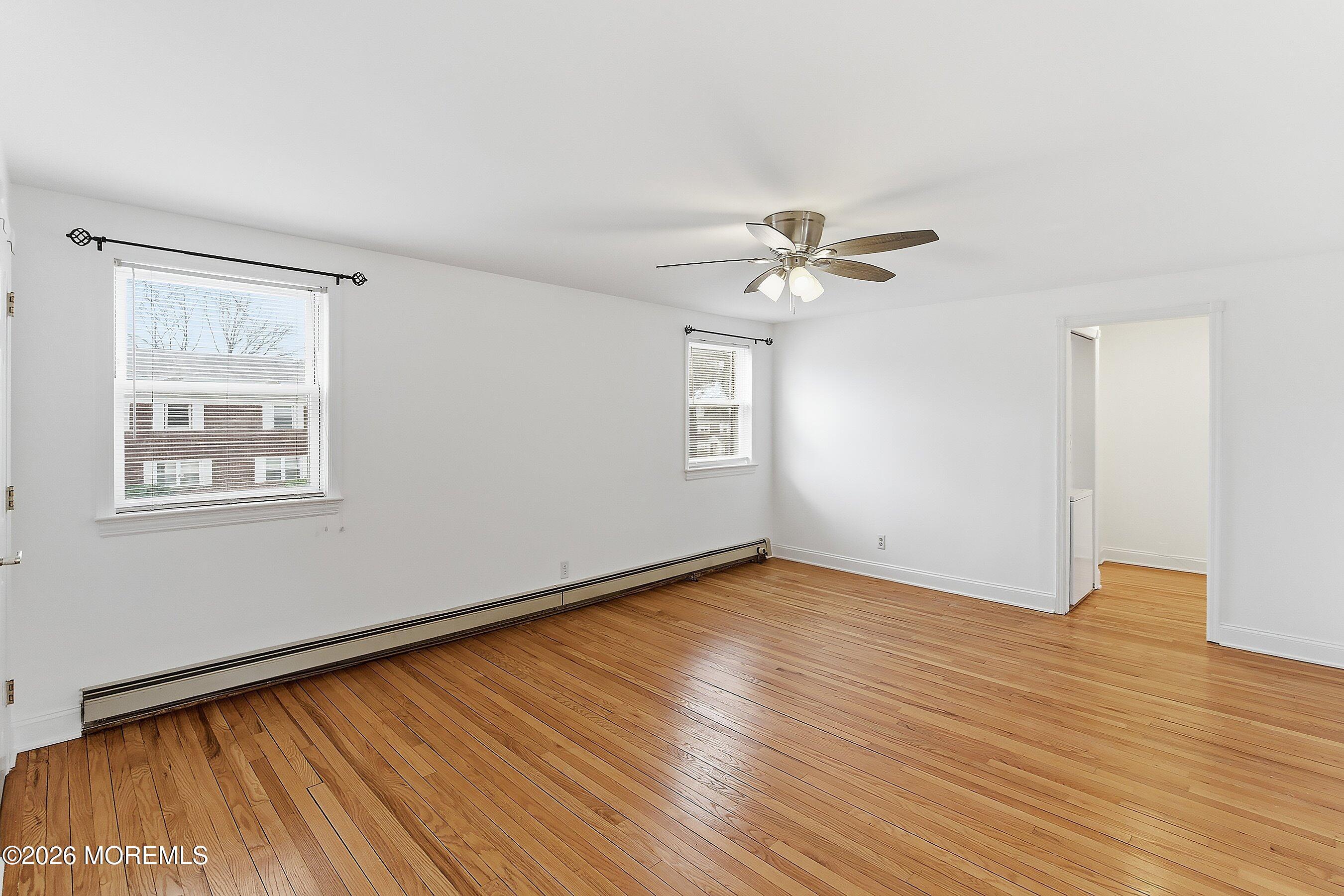 83 Manor Drive Red Bank, NJ 07701 - Photo 4 of 16 an empty room with wooden floor fan and windows