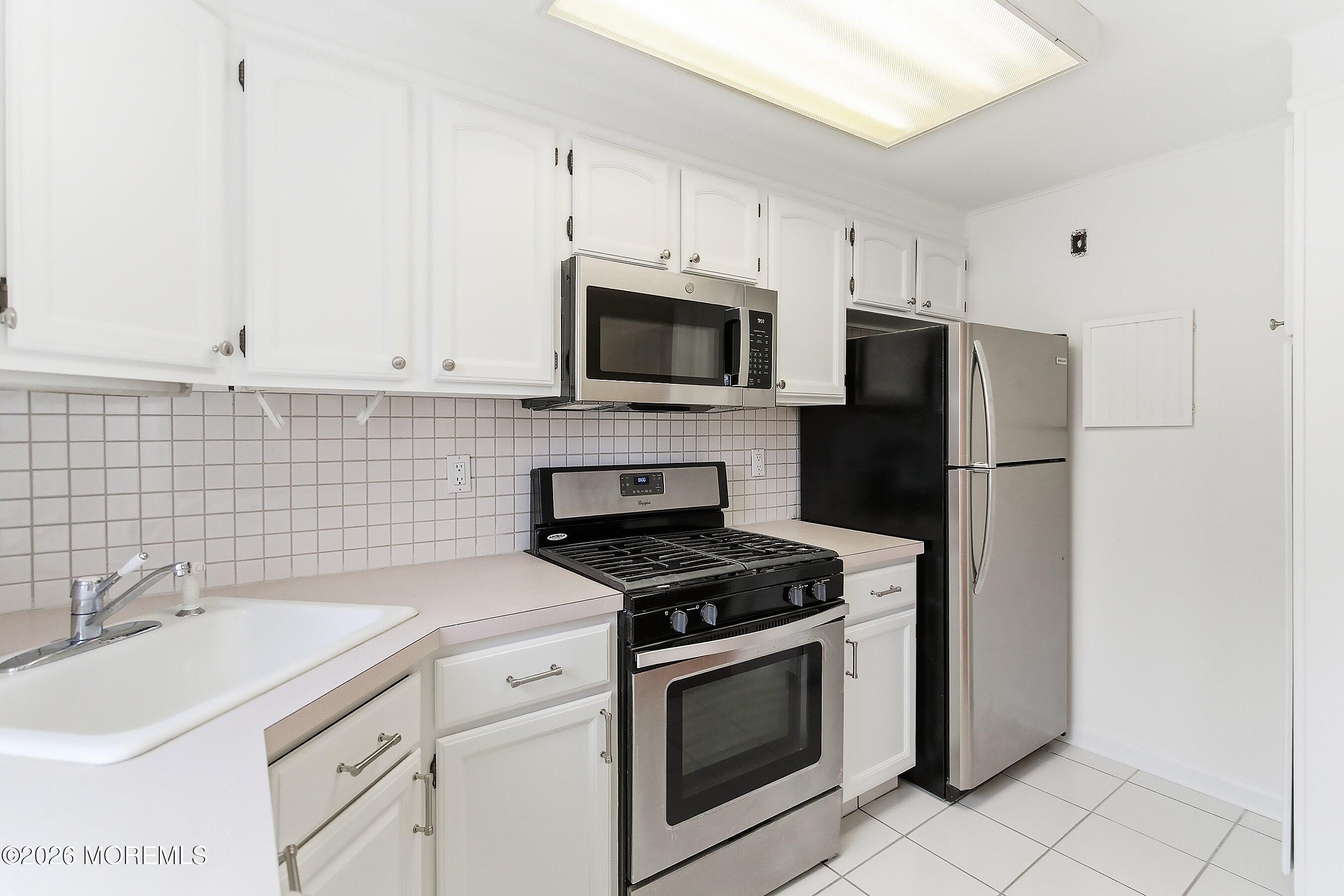83 Manor Drive Red Bank, NJ 07701 - Photo 8 of 16 a kitchen with cabinets stainless steel appliances and a sink