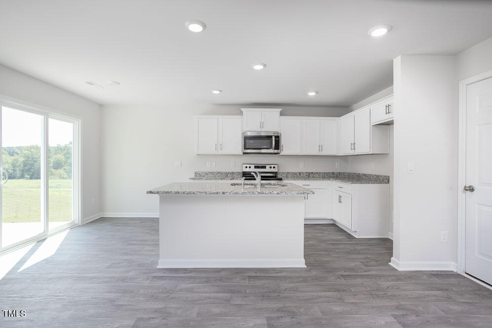 6048 Sodium Street Raleigh, NC 27610 - Photo 11 of 30 a kitchen with a sink microwave and cabinets