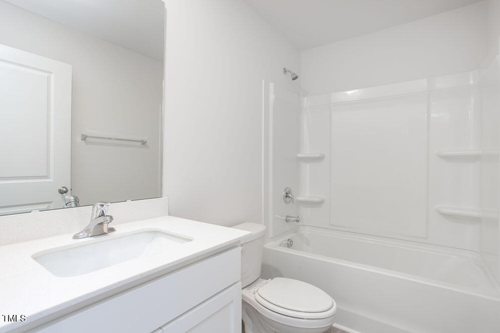 6048 Sodium Street Raleigh, NC 27610 - Photo 25 of 30 a bathroom with a granite countertop sink toilet and shower