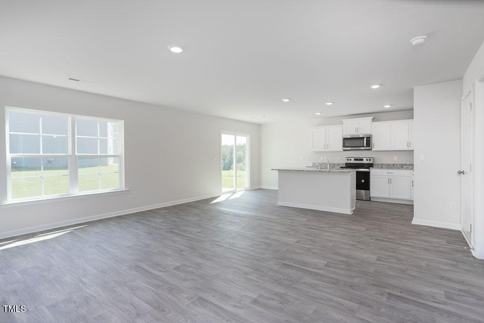 6048 Sodium Street Raleigh, NC 27610 - Photo 7 of 30 a view of kitchen with wooden floor and windows