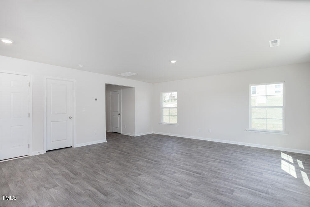 6048 Sodium Street Raleigh, NC 27610 - Photo 9 of 30 an empty room with wooden floor and window