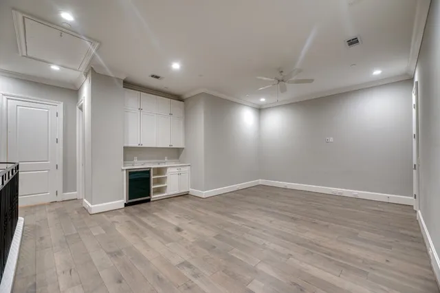 wooden floor in an empty room with a kitchen