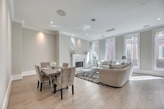 a living room with furniture a large window and wooden floor