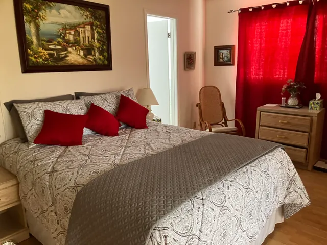 a bedroom with a bed and painting on the wall