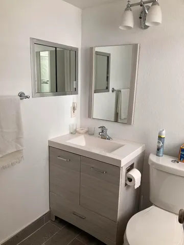 a bathroom with a toilet sink and mirror