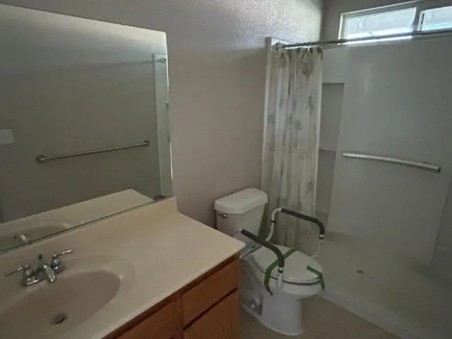 en suite bathroom with a granite countertop sink and a mirror