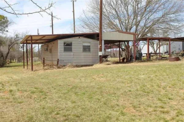 a view of a house with backyard and trees