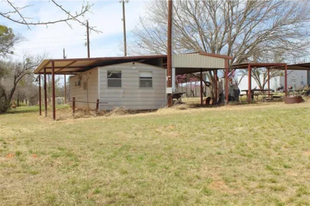 a view of a house with backyard and trees