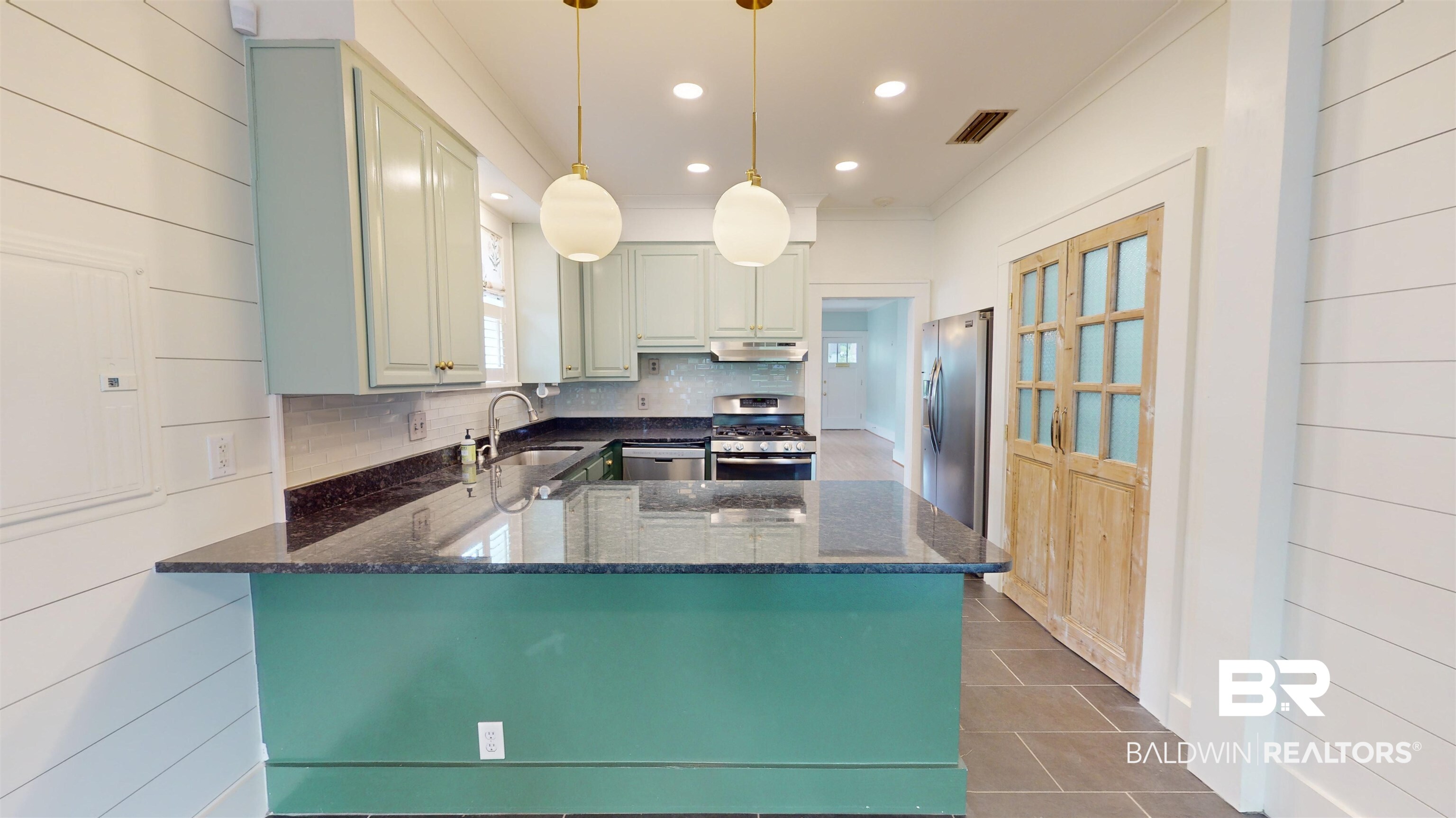 4307 Stein Street Mobile, AL 36608 - Photo 9 of 28 Kitchen featuring stainless steel appliances, dark stone countertops, kitchen peninsula, and pendant lighting