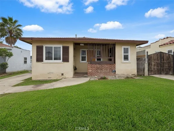 a view of a house with a yard and pathway