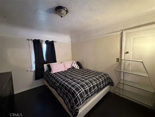 a bed sitting in a bedroom next to a window