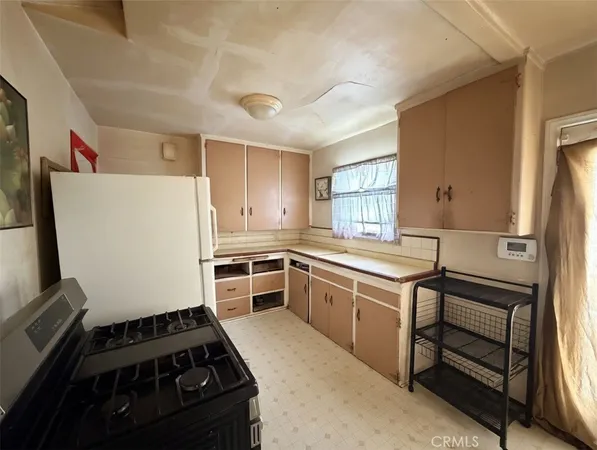 a kitchen with granite countertop a refrigerator stove and sink