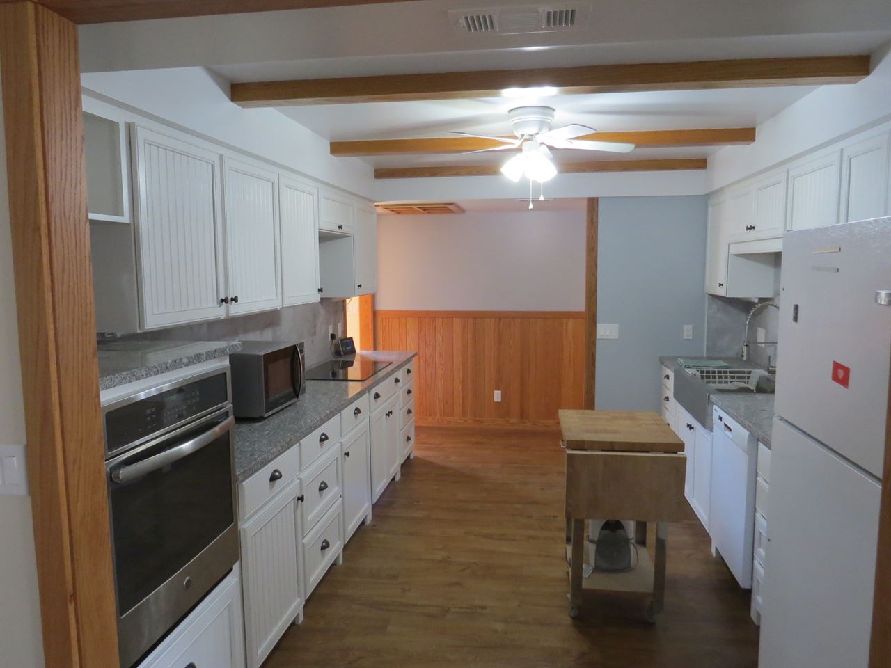 a kitchen with granite countertop a refrigerator a stove a sink and dishwasher