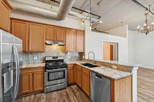 a kitchen with granite countertop a sink stove and refrigerator