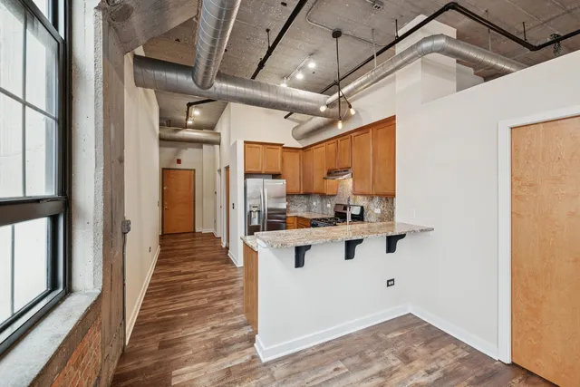 a view of a kitchen with wooden floor and a sink