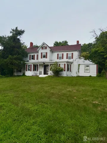 a view of a house with a yard table and chairs