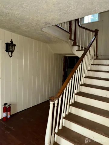 a view of staircase with railing and white walls