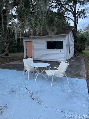 a backyard of a house with table and chairs