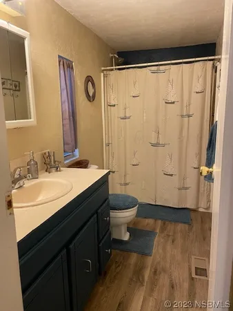 a bathroom with a sink a toilet a mirror and shower