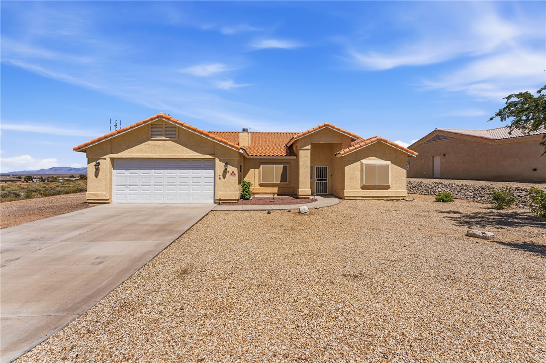 9332 Branded Road Kingman, AZ 86401 - Photo 12 of 44 a front view of a house with a yard and garage