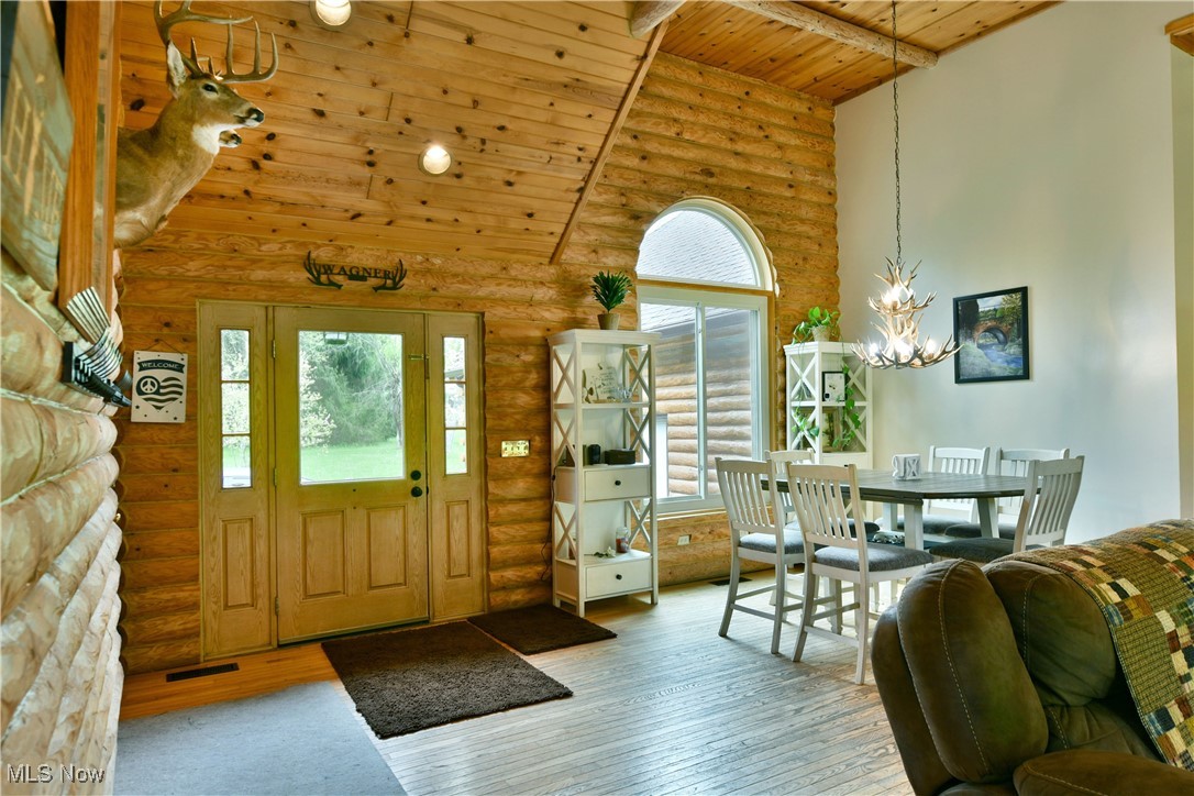 2907 Bushnell Campbell Road Fowler, OH 44418 - Photo 6 of 49 Entrance foyer with rustic walls, a chandelier, plenty of natural light, hardwood / wood-style flooring, and high vaulted ceiling