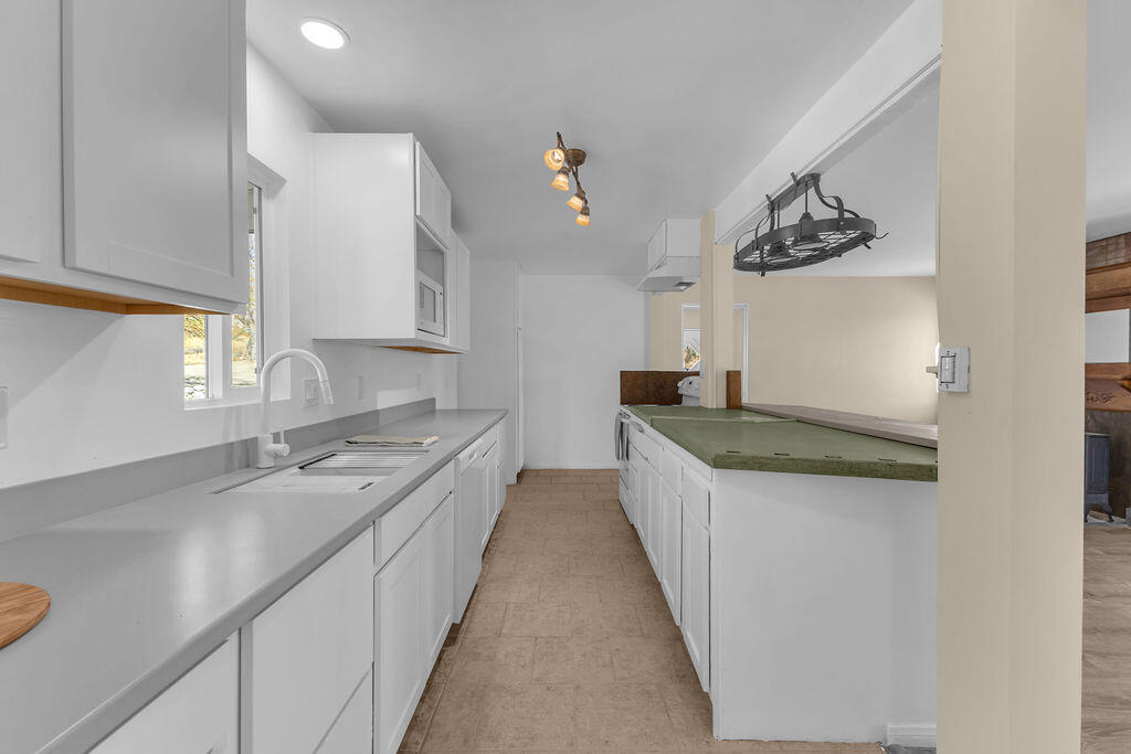 51088 Mecca Road Morongo Valley, CA 92256 - Photo 25 of 77 a kitchen with granite countertop a sink a stove and dishwasher with wooden floor