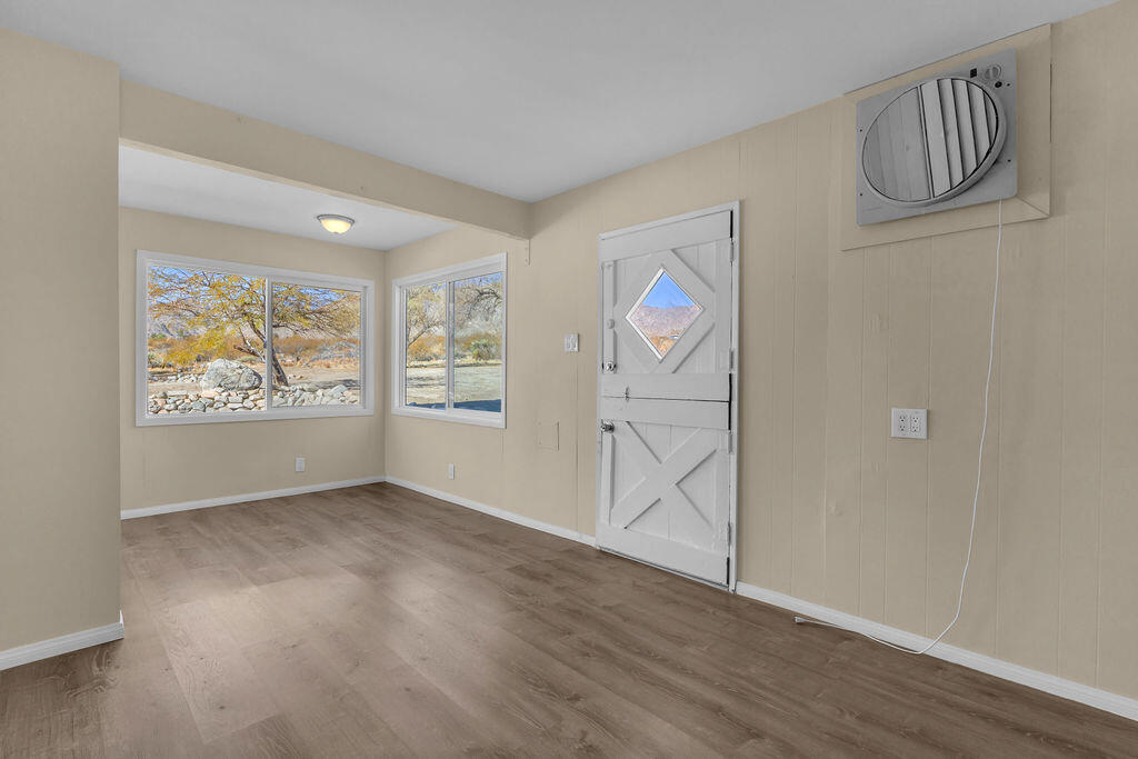 51088 Mecca Road Morongo Valley, CA 92256 - Photo 32 of 77 an empty room with wooden floor and painting on the wall