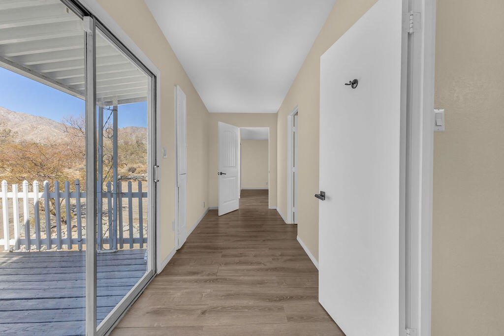 51088 Mecca Road Morongo Valley, CA 92256 - Photo 45 of 77 a view of a hallway with wooden floor and floor to ceiling window