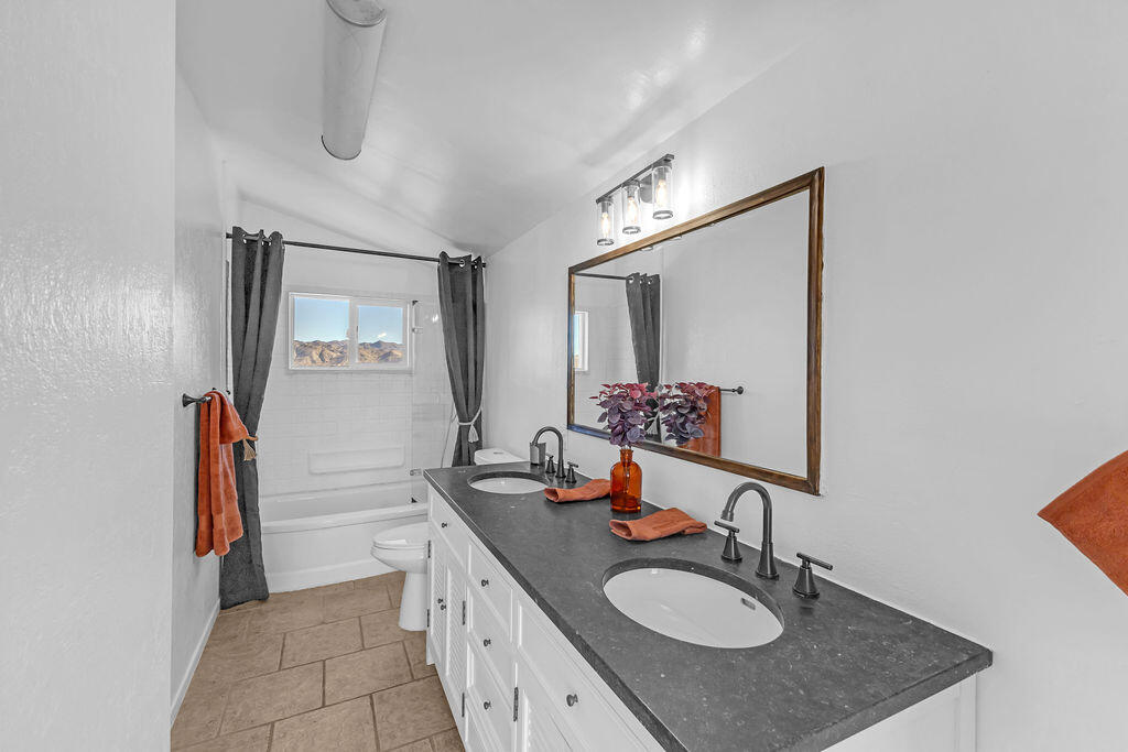 51088 Mecca Road Morongo Valley, CA 92256 - Photo 46 of 77 a bathroom with a granite countertop sink and a mirror