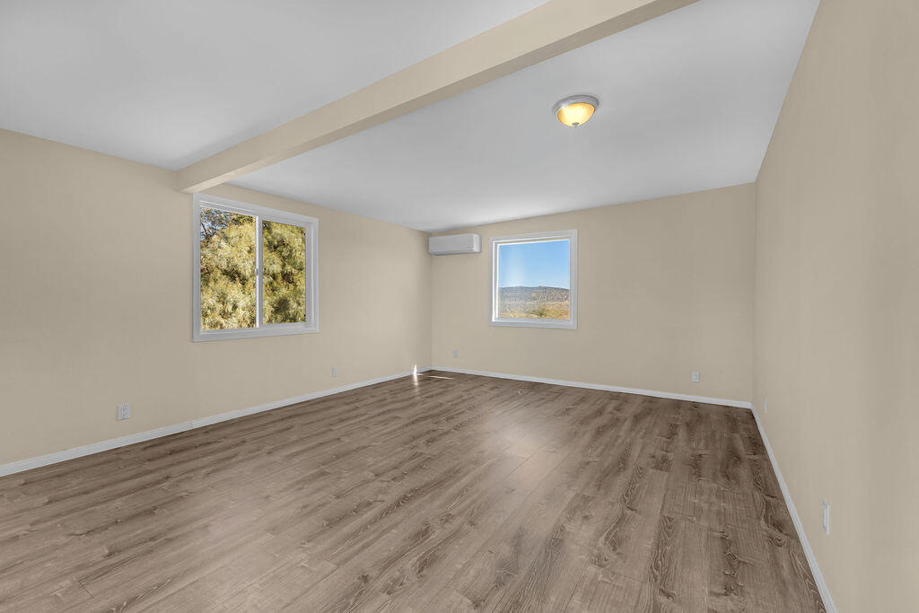 51088 Mecca Road Morongo Valley, CA 92256 - Photo 50 of 77 an empty room with wooden floor and windows