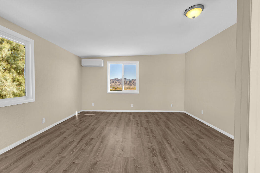 51088 Mecca Road Morongo Valley, CA 92256 - Photo 53 of 77 an empty room with wooden floor and windows