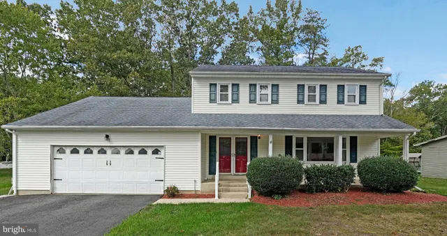 a front view of a house with a yard and potted plants