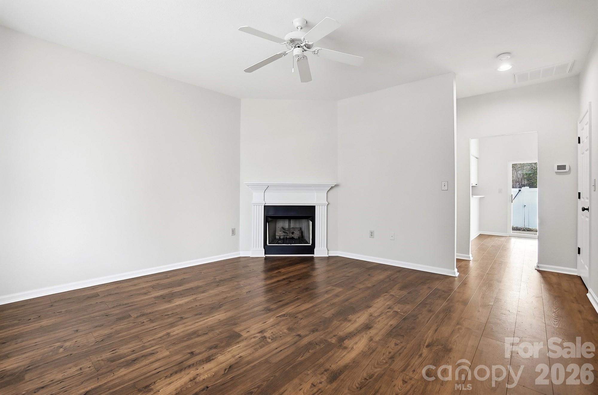 711 Stone Village Drive Fort Mill, SC 29708 - Photo 9 of 46 a view of an empty room with wooden floor a fireplace and a window