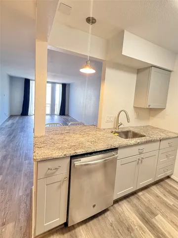 a kitchen with granite countertop white cabinets and a sink