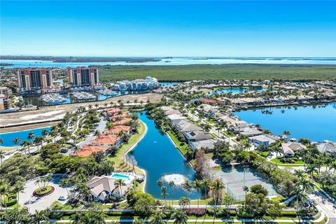 an aerial view of ocean and residential houses with outdoor space