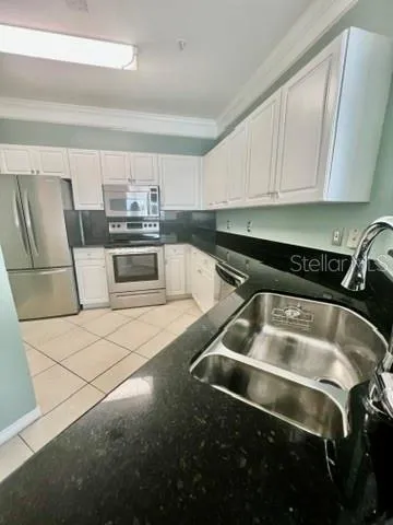 a kitchen with granite countertop a sink and cabinets