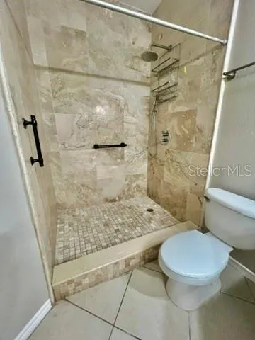 a bathroom with a granite countertop sink a toilet and a shower