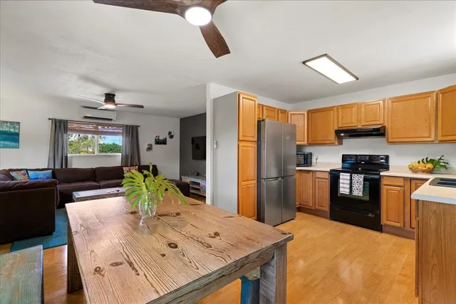 a kitchen with stainless steel appliances kitchen island granite countertop a refrigerator a stove top oven and a sink