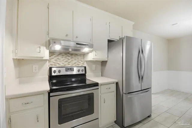 a kitchen with refrigerator a stove and cabinets
