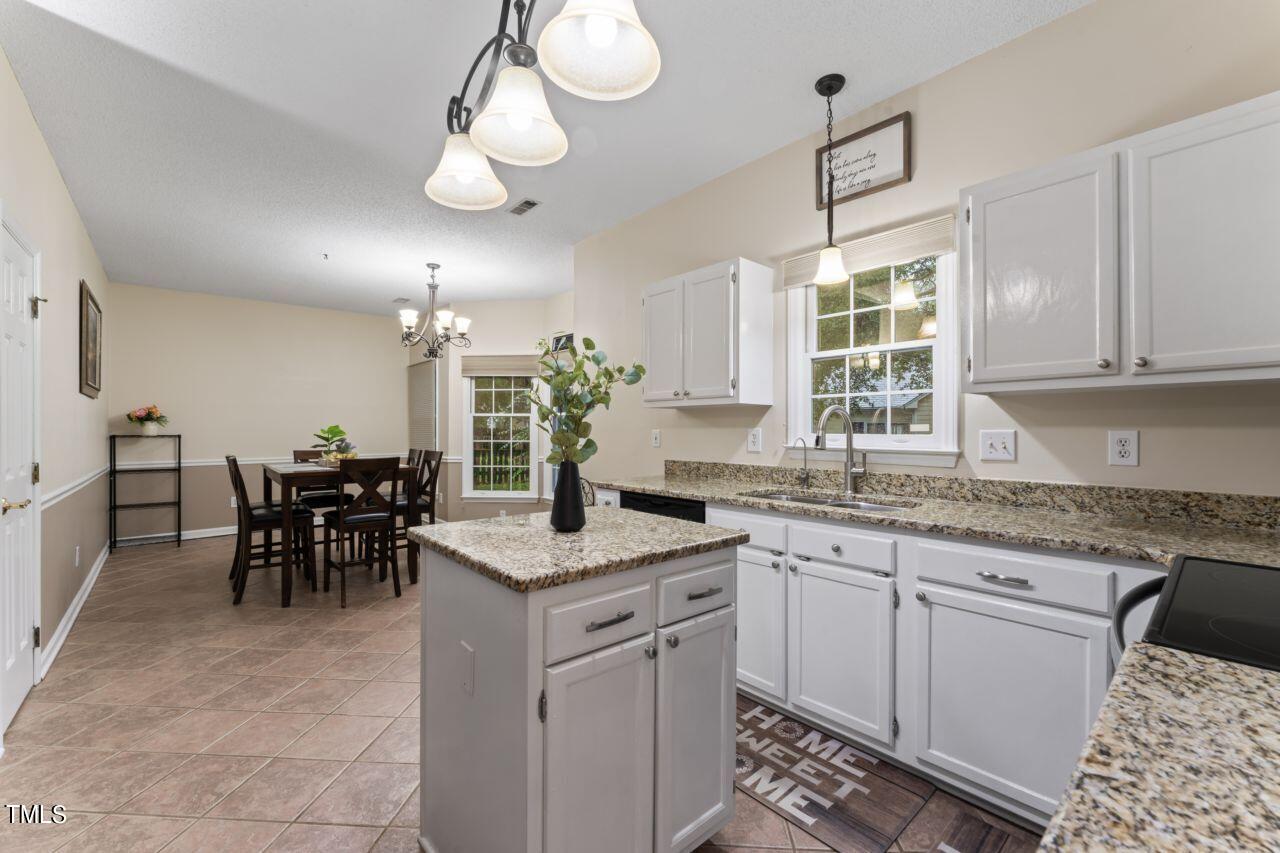 12129 Mabledon Court Raleigh, NC 27613 - Photo 16 of 31 a kitchen with center island table and chairs in it