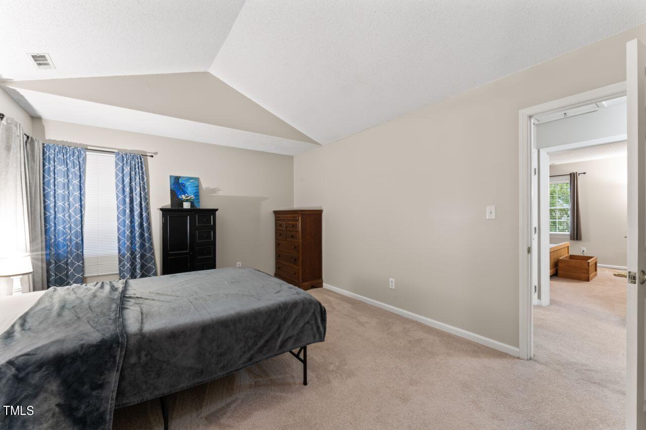 12129 Mabledon Court Raleigh, NC 27613 - Photo 20 of 31 a bedroom with a bed and large mirror