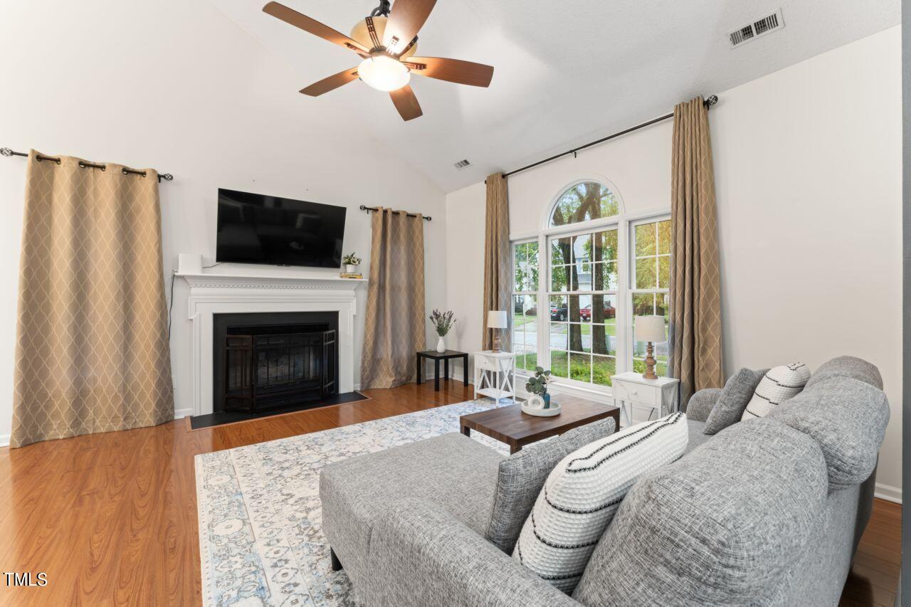 12129 Mabledon Court Raleigh, NC 27613 - Photo 10 of 31 a living room with furniture a fireplace and a flat screen tv