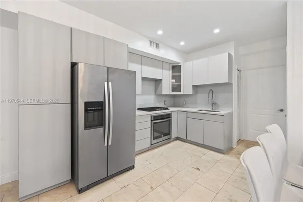 a kitchen with a refrigerator sink and cabinets