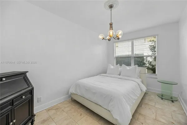 a bedroom with a bed and a chandelier