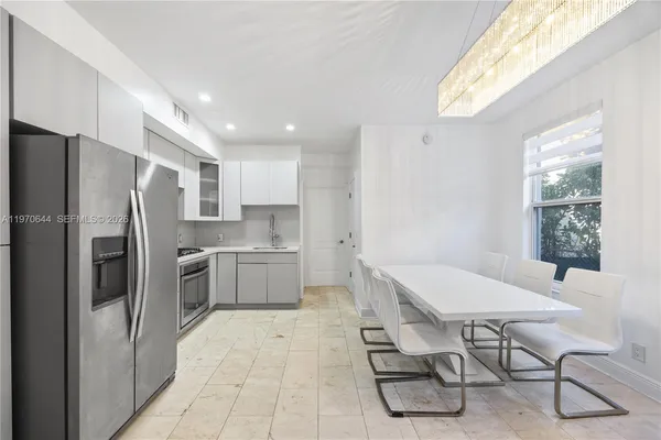 a kitchen with stainless steel appliances a refrigerator and a table