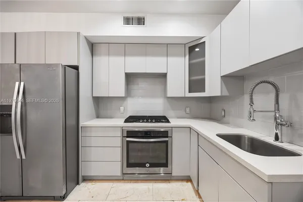 a kitchen with a stove sink and refrigerator